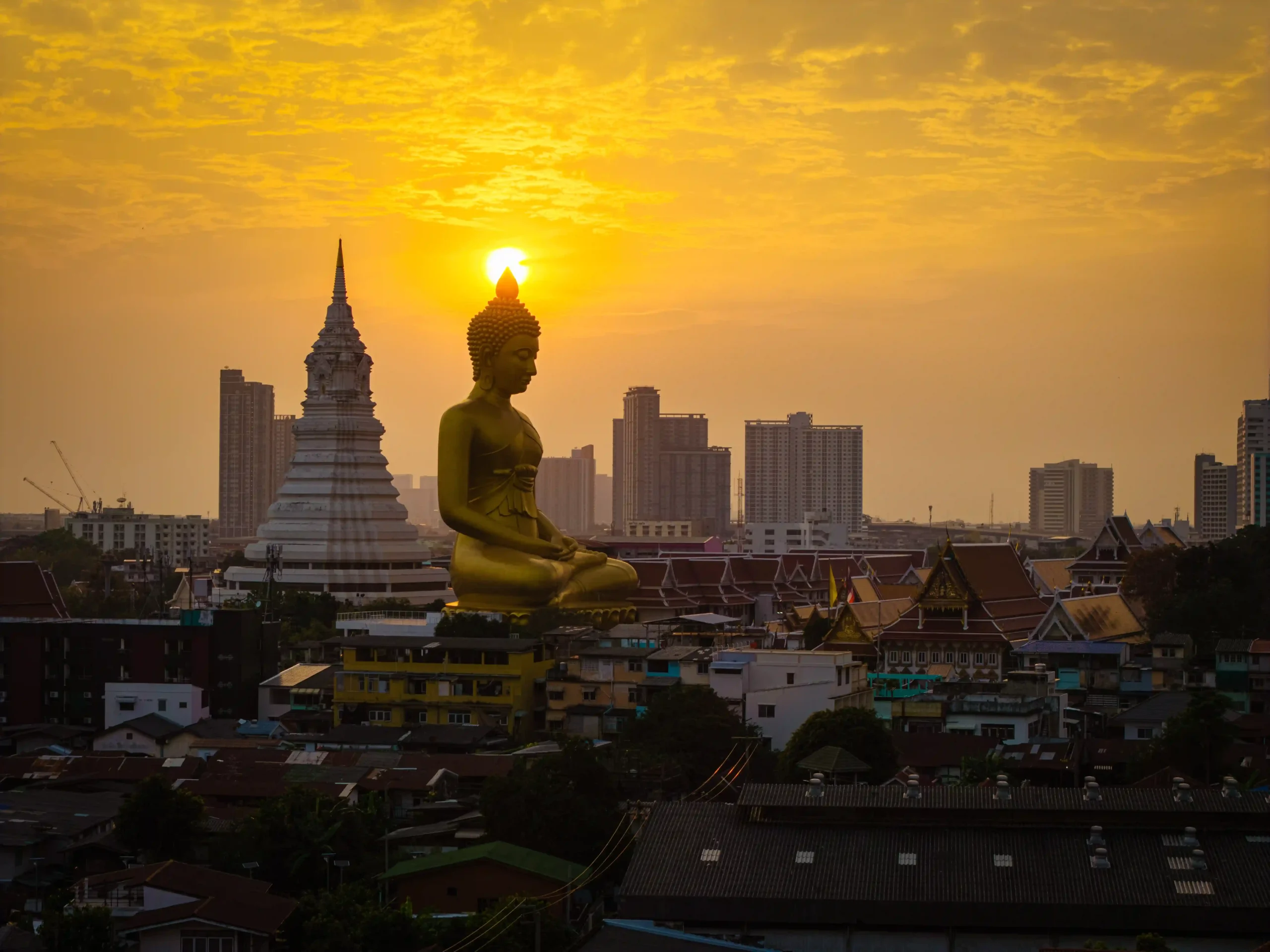 Bangkok skyline with golden Buddha statue at sunset